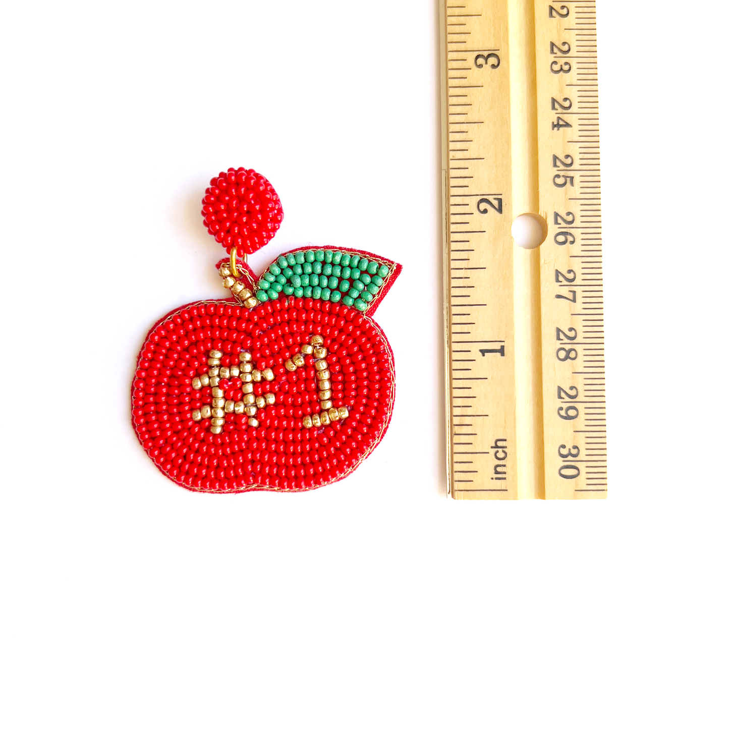 hand beaded apple earring laying next to ruler showing ithe earrings are roughly 2 inches long